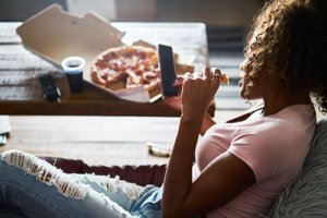 A girl eating pizza wonders how to stop binge eating